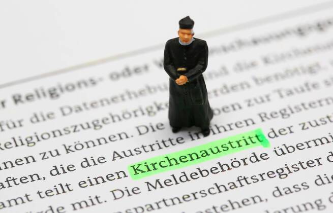 Nuernberg Symbolfoto, Themenbild Kirchenaustritt, Kirchensteuer. Geistlicher mit Soutane steht auf Formular fuer Kirchenaustritt. Copyright: xWuestx Eibner-Pressefotox EP_fwt
