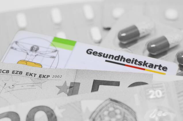 Nuernberg Symbolfoto, Themenbild Krankenversicherung, Krankenkassenbeitrag, Eine farblich hervorgehobene Gesundheitskarte liegt zwischen Arzneimittel und Euro Banknoten, schwarz weiss Foto. Copyright: xWuestx Eibner-Pressefotox EP_fwt
