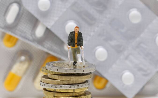Nuernberg Symbolfoto, Themenbild Krankenversicherung, Krankenkassenbeitrag, Arzneimittelkosten. Mann mit Gips und Gehhilfe steht auf Euro Muenzen. Im Hintergrund verschiedene Arzneimittel. Copyright: xWuestx Eibner-Pressefotox EP_fwt