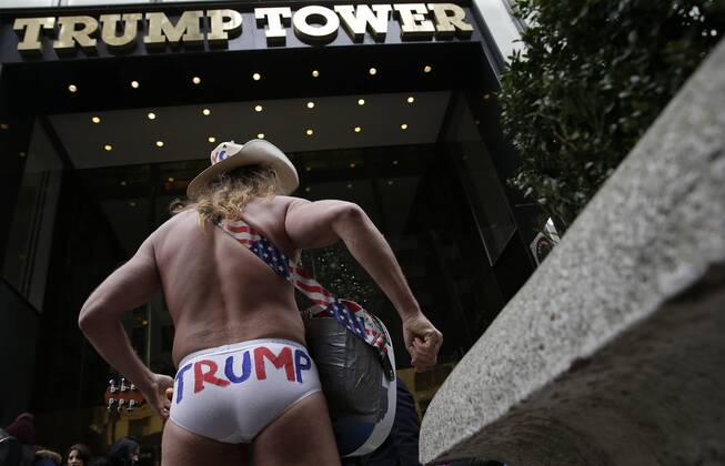 December 11, 2016 - New York, New York, United States of America - An American street musician known as Naked Cowboy plays guitar outside at the entrance to Trump Tower on December 11, 2016 in New York City. U.S. President-elect Donald Trump is still holding meetings upstairs at Trump Tower as he continues to fill in key positions in his new administration. .Credit: Pool via CNP New York United States of America - ZUMAs152 20161211_zaa_s152_002