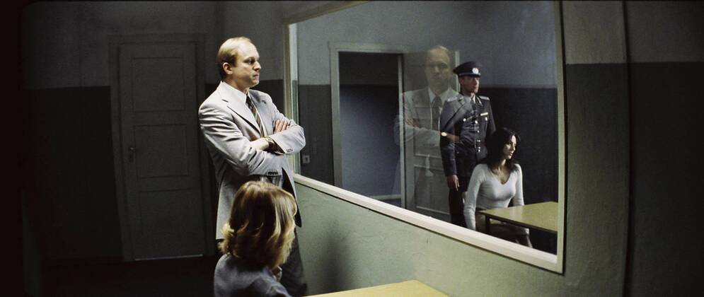 RELEASE DATE: February 9, 2007. MOVIE TITLE: Das Leben der Anderen (North America: The Lives of Others ) - STUDIO: Creado Film Sony Pictures Classics. PLOT: Captain Wiesler (Muhe) is a wiretapping expert with the Stasi (East German Secret Police) in the mid-eighties,who becomes disillusioned with his career and life in general in the former socialist republic when his latest assignment, Georg Dreyman (Koch), a playwright with views against the totalitarian state, starts to challenge his beliefs through his overheard conversations. PICTURED: ULRICH TUKUR (center-left) as Oberstleutnant Anton Grubitz, and MARTINA GEDECK (center-right) as Christa-Maria Sieland. - ZUMAg90_ 20070209_ddn_g90_495