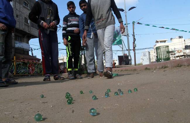 January 19, 2017 - Rafah, Gaza Strip, Palestinian Territory - Palestinian children play marbles in a street in Rafah in the southern Gaza strip on January 19, 2017 Rafah Palestinian Territory - ZUMAap3_ 20170119_zaf_ap3_039