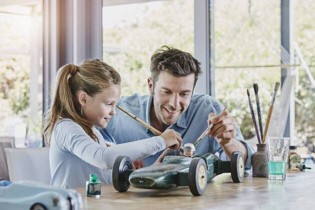 Father and daughter painting a toy race car model released Symbolfoto property released  RORF00479