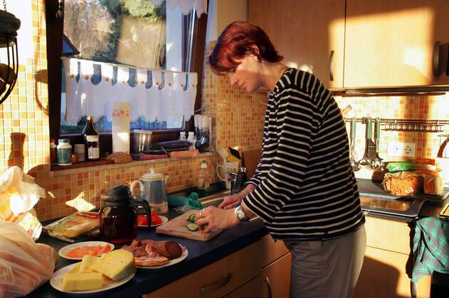 19.11.2005, Zingst, Mecklenburg-Vorpommern, DEU - Eine Frau macht das Fruehstueck. (Mensch, Frau, Gesellschaft, Lebenswelt, Lebenswelten, Alltag, Familie, Mutter, Ernaehrung, Erwachsene, Erwachsener, Essen, Hausfrau, Hunger, hungrig, Kochen, Fruehstueck, Kaese, Wurst, Gurken, Gurke, schneiden, Kaffee, Kaffeekanne, Anrichte, Kueche, Kuechenszene, Speise, Speisen, Zubereitung, zubereiten, Innenaufnahme, Nahrung, Oeko, Oekologisch, Bio, Licht, Lichtstimmung, Kuechenimpressionen, Kuechenimpression, Kuechenutensilien, Essen und Trinken, Abendbrot, digital, QF, Küchenimpressionen, Küchenimpression, Küchenutensilien, Ernährung, Frühstück, Käse, Küche, Küchenszene, Öko, Ökologisch) 00S051119D001.JPG MODEL RELEASE: NO MR:N