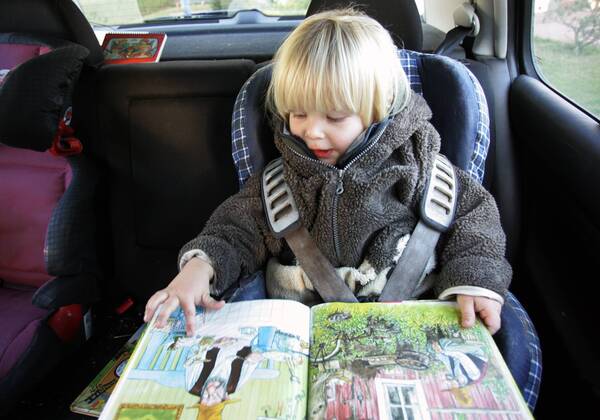 21.11.2005, Zingst, Mecklenburg-Vorpommern, DEU - Ein Kleinkind im Kindersitz schaut sich ein Buch an. (Mensch, Kind, Kleinkind, Kindheit, Junge, Maedchen, Knabe, Bube, Kindersitz, Sitz, Auto, Ruecksitz, Autofahrt, autofahren, Sicherheit, angeschnallt, anschnallen, sichern, Fuersorgepflicht, Buch, Bilderbuch, ansehen, lesen, anschauen, Alltag, Emotion, Mimik, konzentriert, Konzentration, Gesellschaft, Innenaufnahme, Rueckbank, Reise, reisen, Urlaub, Ferien, Ausflug, Verkehr, Autosicherheit, Anschnallpflicht, Verkehrssicherheit, Gurt, Sicherheitsgurt, Gurte, Automobil, Gurtpflicht, Unfall, Unfallvermeidung, Verletzung, Verletzungsvermeidung, Unfallverhuetung, digital, QF, Unfallverhütung, Mädchen, Rücksitz, Fürsorgepflicht) 00S051121D001.JPG MODEL RELEASE: YES MR:Y