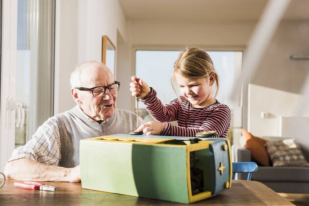 Grandfather and granddaughter assembling toy bus model released Symbolfoto property released  UUF09549