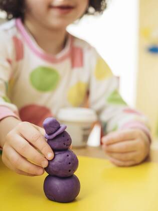 Girl making snowman out of modelling clay model released Symbolfoto property released  KRPF02095