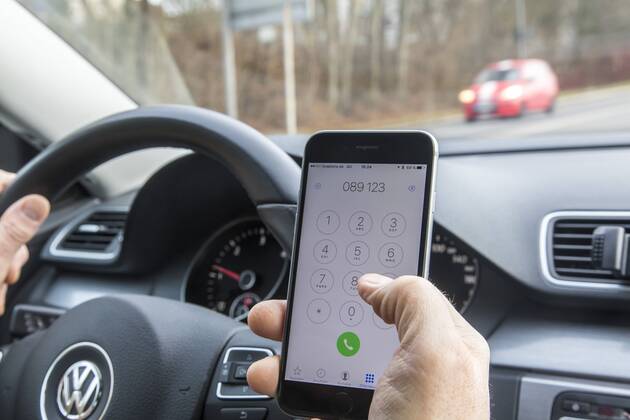 Mann, Autofahrer, benutzt ein Handy, während der Fahrt, wählt Telefonnummer, ohne Freisprecheinrichtung,