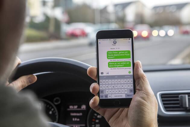 Mann, Autofahrer, benutzt ein Handy, während der Fahrt, SMS schreiben,