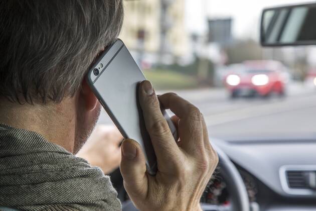 Mann, Autofahrer, benutzt ein Handy, während der Fahrt, ohne Freisprecheinrichtung,