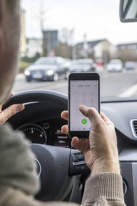 Mann, Autofahrer, benutzt ein Handy, während der Fahrt, wählt Telefonnummer, ohne Freisprecheinrichtung,