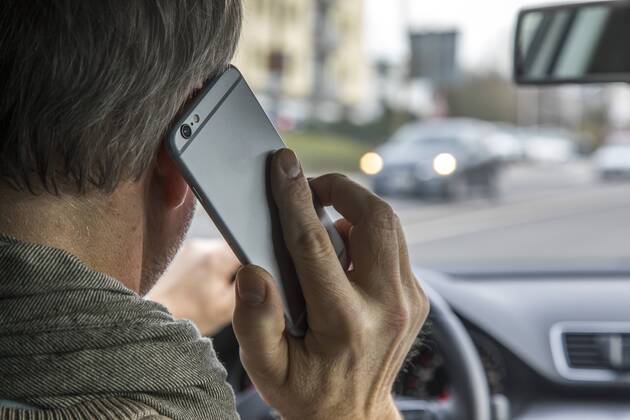 Mann, Autofahrer, benutzt ein Handy, während der Fahrt, ohne Freisprecheinrichtung,