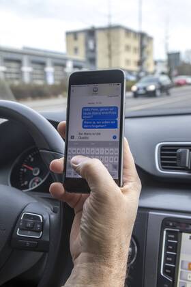 Mann, Autofahrer, benutzt ein Handy, während der Fahrt, SMS schreiben,