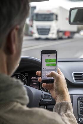 Mann, Autofahrer, benutzt ein Handy, während der Fahrt, SMS schreiben,