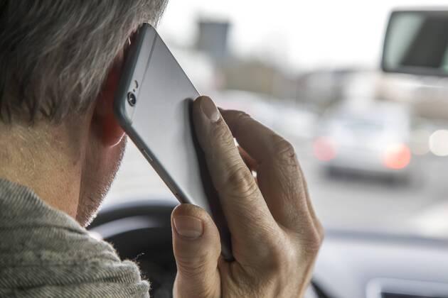 Mann, Autofahrer, benutzt ein Handy, während der Fahrt, ohne Freisprecheinrichtung,