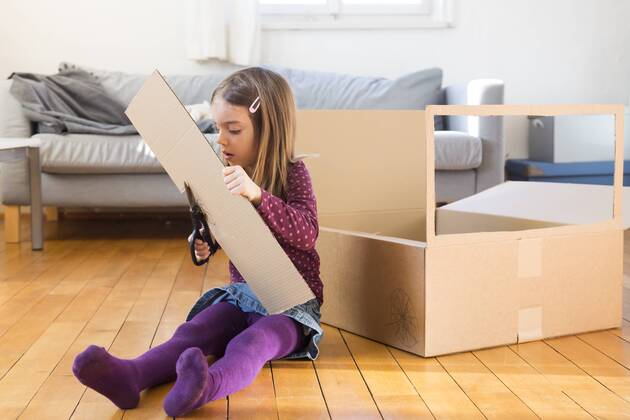 Girl tinkering with cardboard box at home model released Symbolfoto  LVF05805