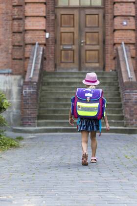 IMAGO Creative: Gesellschaft, Schule, Schulanfang Back view of little girl with school bag in front of her school model released Symbolfoto  JFEF00836