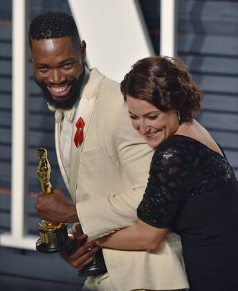 Writer Tarell Alvin McCraney (L) and producer Adele Romanski celebrate their Oscar wins for Moonlight as they arrive for the Vanity Fair Oscar Party at the Wallis Annenberg Center for the Performing Arts in Beverly Hills, California on February 26, 2017.  LAP201702262103 CHRISTINExCHEW