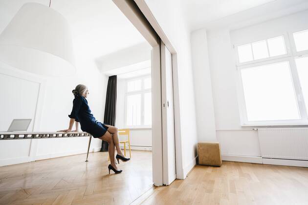 Businesswoman sitting on table in modern office model released Symbolfoto property released  KNSF01808
