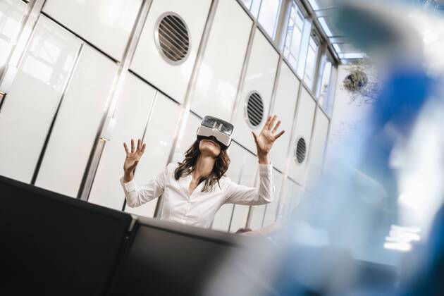 Businesswoman using VR goggles in office model released Symbolfoto property released KNSF02040