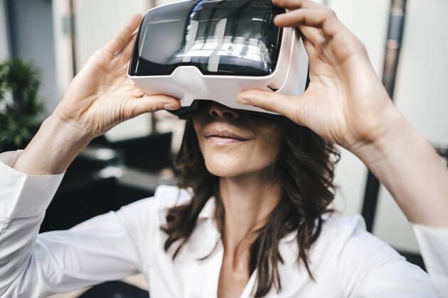 Businesswoman using VR goggles in office model released Symbolfoto property released  KNSF02041