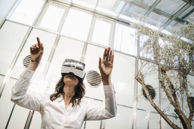 Businesswoman using VR goggles in office model released Symbolfoto property released KNSF02043