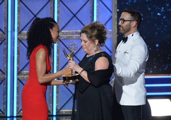 Actor Ann Dowd accepts the award for Outstanding Supporting Actress in a Drama Series for The Handmaid s Tale from actors Sonequa Martin-Green and Jeremy Piven, onstage during the 69th annual Primetime Emmy Awards at Microsoft Theater in Los Angeles on September 17, 2017.  LAP201709170209 JIMxRUYMEN