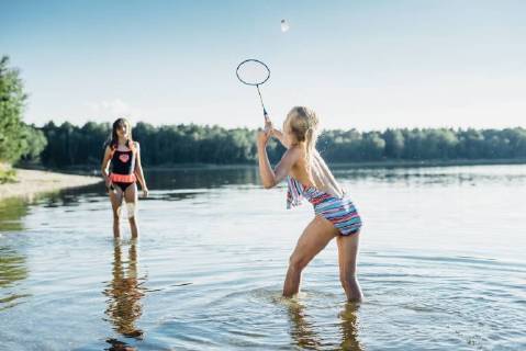 Two friends playing shuttlecock at lakeshore model released Symbolfoto  MJF02186