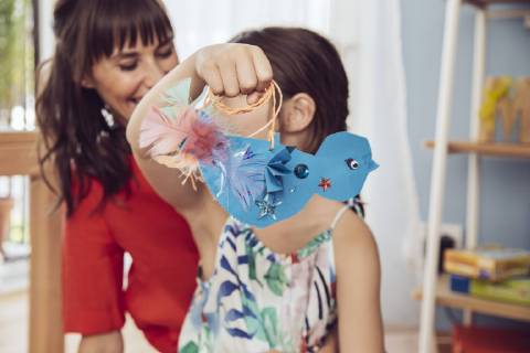 Mother and daughter playing with self made paper bird model released Symbolfoto property released  MFF03804