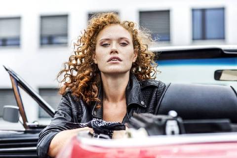 Portrait of confident redheaded woman in sports car model released Symbolfoto FMKF04518