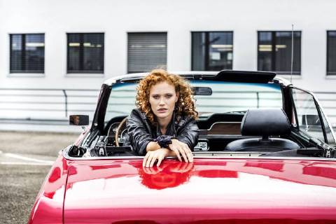 Portrait of confident redheaded woman in sports car model released Symbolfoto FMKF04520