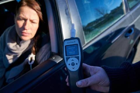 Junge Frau mit Handy am Steuer eines PKW (gestellte Szene) bei einer Polizeikontrolle mit Alkoholkontrolle, Promille, Polizistin, in Marktoberdorf, Bayern, Deutschland am 07.12.2017 FRAU AM STEUER MODEL RELEASED