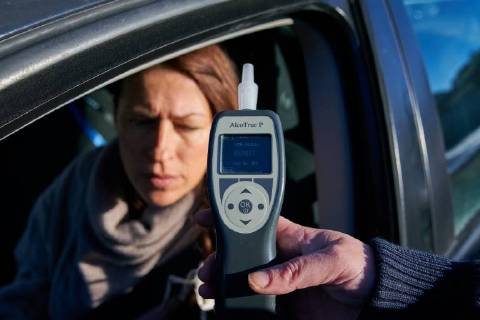 Junge Frau mit Handy am Steuer eines PKW (gestellte Szene) bei einer Polizeikontrolle mit Alkoholkontrolle, Promille, Polizistin, in Marktoberdorf, Bayern, Deutschland am 07.12.2017 FRAU AM STEUER MODEL RELEASED