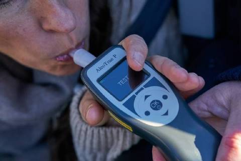 Junge Frau mit Handy am Steuer eines PKW (gestellte Szene) bei einer Polizeikontrolle mit Alkoholkontrolle, Promille, Polizistin, in Marktoberdorf, Bayern, Deutschland am 07.12.2017 FRAU AM STEUER MODEL RELEASED