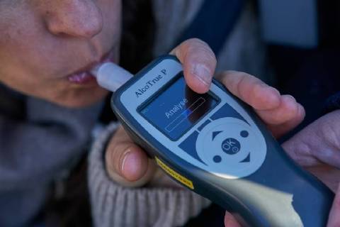 Junge Frau mit Handy am Steuer eines PKW (gestellte Szene) bei einer Polizeikontrolle mit Alkoholkontrolle, Promille, Polizistin, in Marktoberdorf, Bayern, Deutschland am 07.12.2017 FRAU AM STEUER MODEL RELEASED