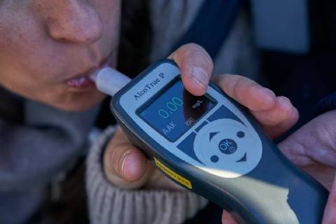Junge Frau mit Handy am Steuer eines PKW (gestellte Szene) bei einer Polizeikontrolle mit Alkoholkontrolle, Promille, Polizistin, in Marktoberdorf, Bayern, Deutschland am 07.12.2017 FRAU AM STEUER MODEL RELEASED