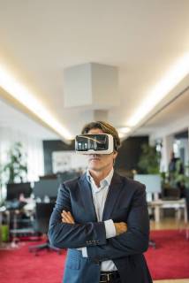 Businessman wearing VR glasses in office model released Symbolfoto property released  JOSF01835