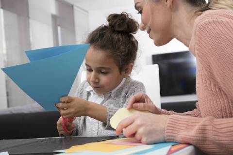 Mother and little daughter tinkering with colored fancy paper model released Symbolfoto  GDF01191