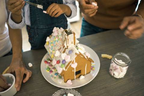 Family pasting gingerbread house in kitchen for Christmas with sweets model released Symbolfoto property released  MOEF00379