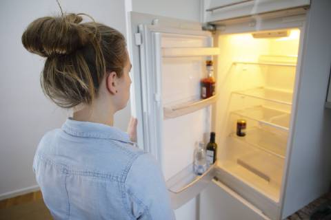 Gestellte Aufnahme: Eine Frau schaut in einen leeren Kuehlschrank. Berlin, 13.02.2018. Berlin Deutschland