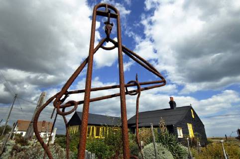 Picture by Roger Bamber: 1 September 2007 : Prospect Cottage, the former home of the late artist and film director Derek Jarman at Dungeness,on Romnet Marsh, Kent. The house and its dry shingle garden is photographed through one of his many sculptures made from iron and driftwood., Copyright: Topfoto !ACHTUNG AUFNAHMEDATUM GESCHÄTZT! UnitedArchives1388195