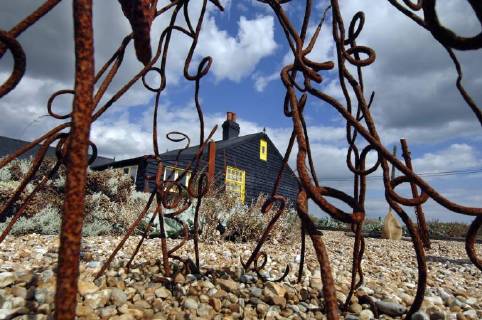 Picture by Roger Bamber: 1 September 2007 : Prospect Cottage, the former home of the late artist and film director Derek Jarman at Dungeness,on Romnet Marsh, Kent. The house and its dry shingle garden is photographed through one of his many sculptures made from iron and driftwood., Copyright: Topfoto !ACHTUNG AUFNAHMEDATUM GESCHÄTZT! UnitedArchives1388196