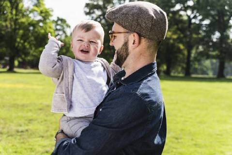 Happy father carrying son in a park model released Symbolfoto UUF13807