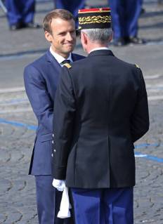French President Emmanuel Macron speaks with a French military officer before the start of the annual Bastille Day military parade along Avenue des Champs-Elysees in Paris on July 14, 2018. PAR20180714042 DAVIDxSILPA