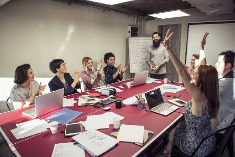 Colleagues celebrating good news during a meeting  Copyright: EricxAudras B40737731