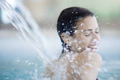 Woman relaxing under fountain in pool  Copyright: AlexVentura B41269927