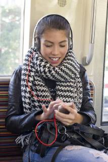 Young woman using smartphone on subway train Copyright: FrédéricxCirou B16363722