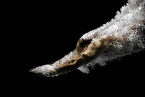 An image of a diving man in a black pool