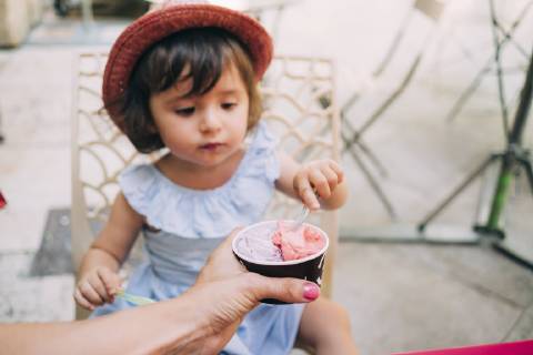 Cute toddler girl eating an ice cream held by her mother model released Symbolfoto  GEMF02115