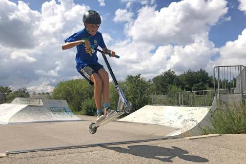 Junge,Kind (11 Jahre alt) faehrt auf einem Stunt Scooter in eine Skatepark,Skaterbahn,